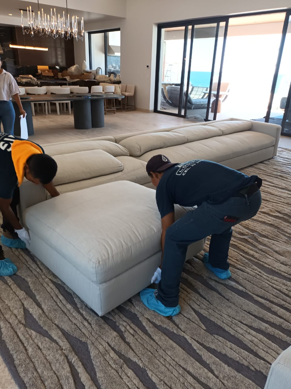 AG crew installing a large sectional sofa in a luxury home