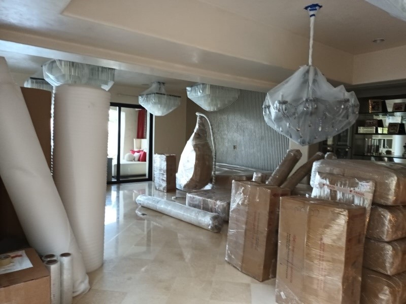 Wrapped chandelier and high-value fixtures staged for transit inside a luxury residence